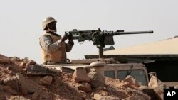 FILE - A Saudi soldier sits on top of an armor vehicle as he aims his weapons, on the border with Yemen, at a military point in Najran, Saudi Arabia, April 21, 2015. 