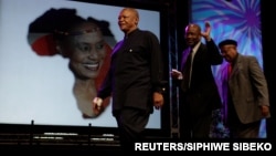 FILE - Tombonist and composer Jonas Gwangwa, right, walks on stage trumpeter Hugh Masekela (L) and Caiphus Semenya after paying tribute during Miriam Makeba's memorial service in Johannesburg November 15, 2008.