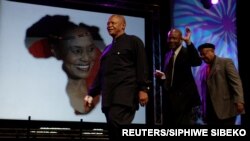 FILE - Trombonist and composer Jonas Gwangwa, right, walks on stage trumpeter Hugh Masekela (L) and Caiphus Semenya after paying tribute during Miriam Makeba's memorial service in Johannesburg November 15, 2008.