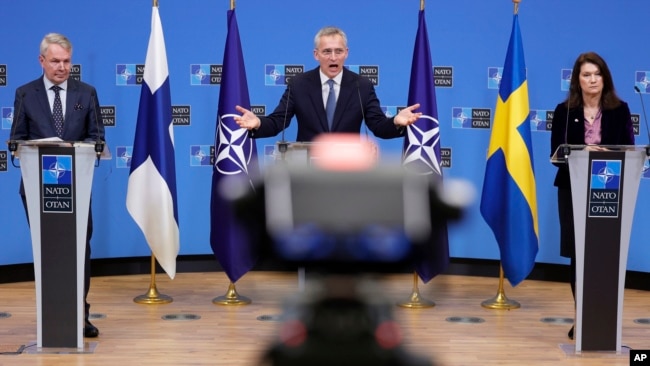 NATO Secretary General Jens Stoltenberg, center, participates in a media conference with Finland's Foreign Minister Pekka Haavisto, left, and Sweden's Foreign Minister Ann Linde, right, at NATO headquarters in Brussels, Monday, Jan. 24, 2022. (AP Photo/Olivier Matthys)