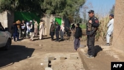 Petugas polisi berkumpul di lokasi serangan oleh pria bersenjata terhadap seorang polisi yang menjaga tim vaksinasi polio di Kohat, sekitar 75 km barat daya Peshawar pada 25 Januari 2022. (Foto "AFP)