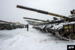 Un militar de las Fuerzas Militares de Ucrania se para frente a los tanques de la brigada 92 mecanizada separada de las Fuerzas Armadas de Ucrania, estacionados en su base cerca de la aldea de Klugino-Bashkirivka, en la región de Kharkiv el 31 de enero de 2022