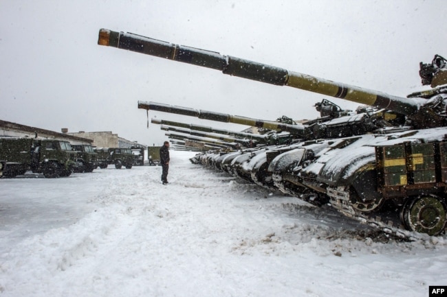 Un militar de las Fuerzas Militares de Ucrania se para frente a los tanques de la brigada 92 mecanizada separada de las Fuerzas Armadas de Ucrania, estacionados en su base cerca de la aldea de Klugino-Bashkirivka, en la región de Kharkiv el 31 de enero de 2022