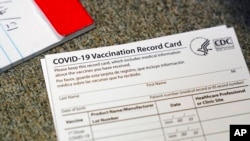 Karton sa podacima o vakcinaciji (Foto: AP/Jeff Chiu)