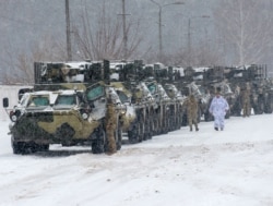 Pengangkut personel lapis baja (APC) dari brigade mekanis terpisah ke-92 Angkatan Bersenjata Ukraina pindah ke pangkalan mereka di dekat desa Klugino-Bashkirivka, di wilayah Kharkiv pada 31 Januari 2022. (Foto: AFP)