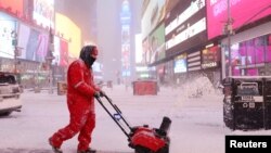 纽约市曼哈顿区的工人在铲雪（2022年1月19日）