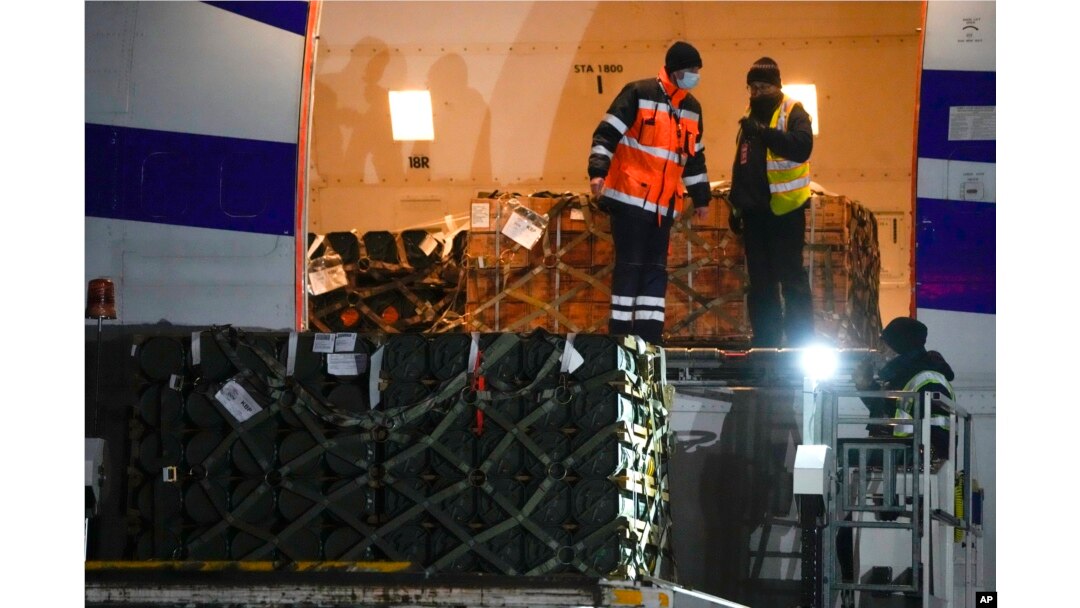 Pekerja membongkar kiriman bantuan militer yang dikirim sebagai bagian dari bantuan keamanan Amerika Serikat ke Ukraina, di bandara Boryspil, di luar Kyiv, Ukraina, 25 Januari 2022. (Foto: AP)