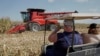 Visitors to the Husker Harvest Days farm show in Grand Island, Neb., follow a corn harvesting demonstration, Sept. 10, 2019. 