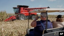 Visitors to the Husker Harvest Days farm show in Grand Island, Neb., follow a corn harvesting demonstration, Sept. 10, 2019. 