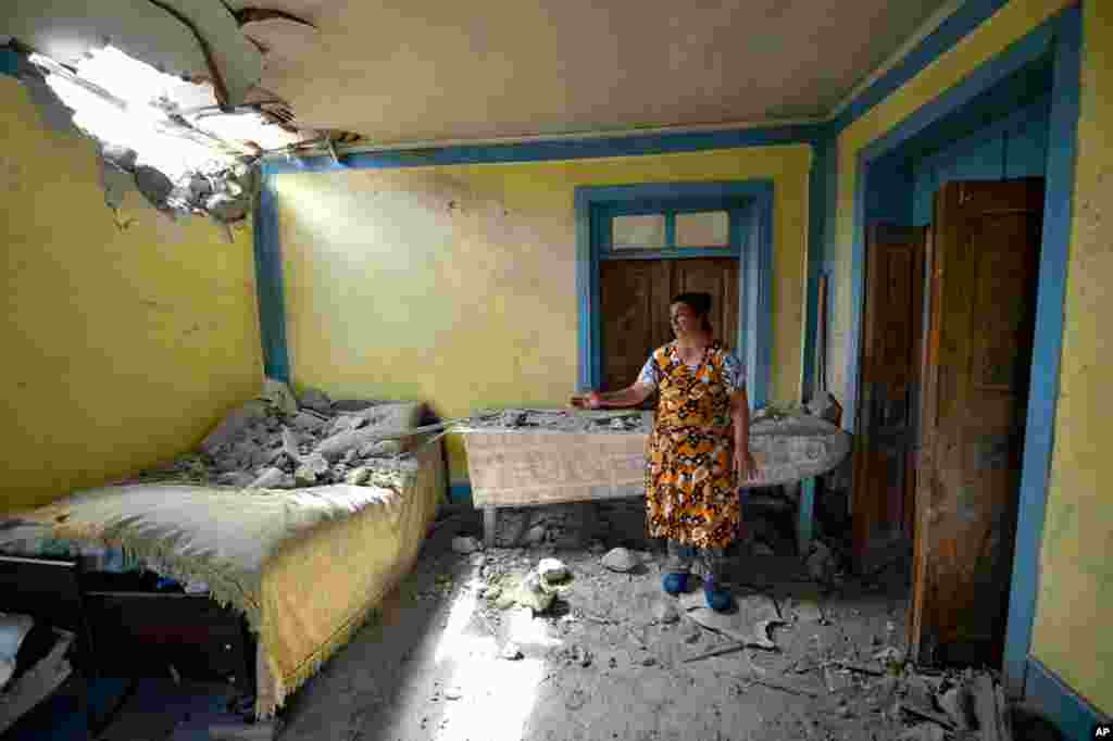 A local woman shows the damage inflicted on her house after the shelling by Armenian forces in the Tovuz region of Azerbaijan. Skirmishes escalated on the volatile Armenia-Azerbaijan border.