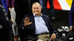FILE - Former president George H. W. Bush waves as he arrives at a sports stadium in Houston, Texas, April 2, 2016.
