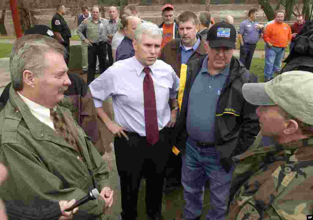 Indiana Gov. Mitch Daniels, right, talks about the flooding in Indiana to Rep. Mike Sodrel, R-Ind, left, Rep. Mike Pence, R-Ind., and Fred Armstrong, Mayor of Columbus, during a stop in Columbus, Jan. 12, 2005.