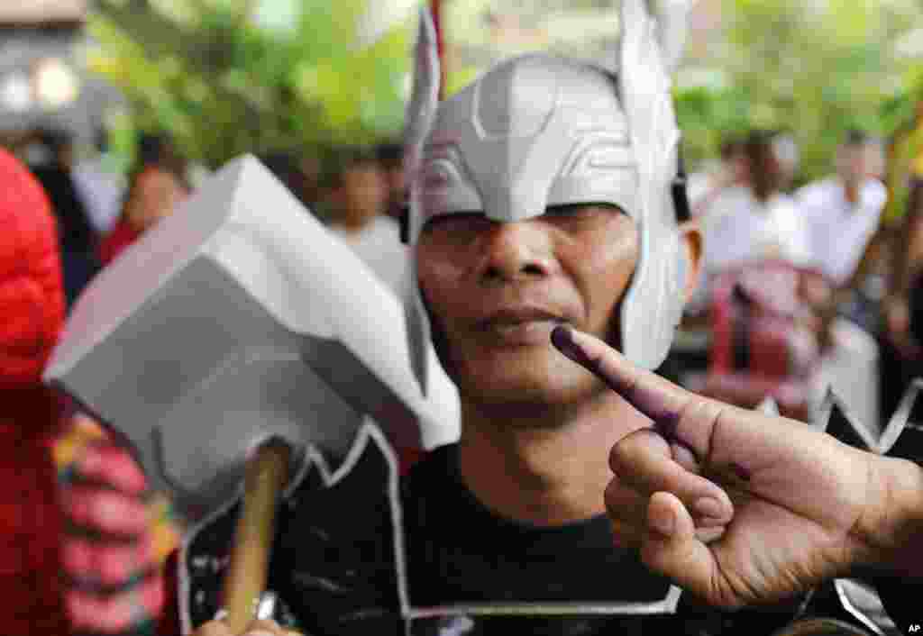 Seorang pria berkostum&nbsp;tokoh super hero&nbsp; &quot;Thor&quot; menunjukkan jarinya usai melaksanakan hak pilih di sebuah TPS di Bali, Rabu, 17 April 2019. (Foto: Firdia Lisnawati/AP)