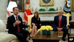 President Donald Trump and first lady Melania Trump listen as acting FDA Commissioner Ned Sharpless talks about a plan to ban most flavored e-cigarettes, in the Oval Office of the White House, Wednesday, Sept. 11, 2019, in Washington. (AP Photo/Evan Vucci