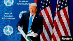 El presidente Donald Trump enseña un libro de regulaciones del gobierno antes de un discurso en el Departamento de Transporte en Washington D.C. Junio 9, 2017. 
