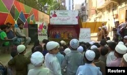 Children watch a puppet show organized by Thespianz Theatre that teaches inter-faith harmony, in the Lyari neighborhood, Karachi, Pakistan.