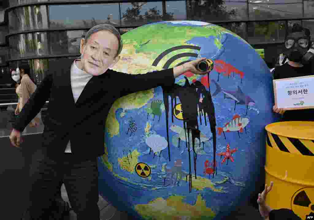 A South Korean environmental activist wearing a mask of Japan&#39;s Prime Minister Yoshihide Suga performs during a protest against Japan&#39;s decision to discharge Fukushima wastewater into the sea, near the Japanese embassy in Seoul.