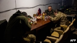 Ukrainian servicemen have lunch in their underground shelter in the frontline town of Bakhmut, in eastern Ukraine's Donetsk region on October 31, 2022. Since Russia's invasion of Ukraine, Bakhmut has been one of the most lethal battlefields for both sides.