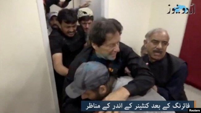 Former Pakistani Prime Minister Imran Khan is helped after he was reportedly shot in the shin, in Wazirabad, Pakistan, Nov. 3, 2022, in this still image obtained from video. (Urdu Media via Reuters)