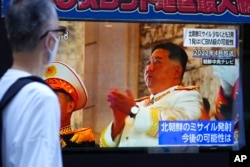 A person watches a TV screen showing the news report about North Korea's recent missile launches near Japan, in Tokyo, Nov. 3, 2022.