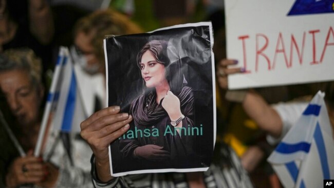 FILE - Women attend a protest against the death of Mahsa Amini, a woman who died while in police custody in Iran, during a rally in Tel Aviv, Oct. 29, 2022. Amini, 22, was held by morality police for allegedly wearing the mandatory Islamic headscarf too loosely.