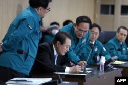 This handout photo taken and released on November 2, 2022 by the South Korean Presidential Office via Yonhap news agency shows South Korean President Yoon Suk-yeol (C) speaking at a meeting of the National Security Council over North Korea's missile launch, at the presidential office in Seoul.