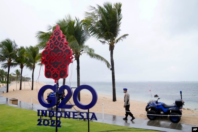 Seorang polisi berjalan melewati tanda G20 di Nusa Dua, Bali, Kamis, 7 Juli 2022. (Foto: AFP)