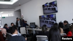 Periodistas observan la audiencia del tribunal de la Jurisdicción Especial para la Paz (JEP) en pantallas en Bogotá, Colombia, el 23 de septiembre de 2019.