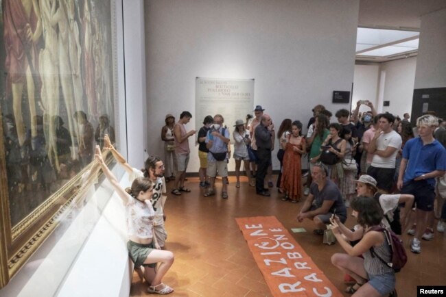 Protesters glue themselves to Botticelli's "Primavera" in the Uffizi Gallery, in Florence, Italy July 22, 2022, in this still image obtained from a handout video. (Ultima Generazione/Handout via REUTERS)