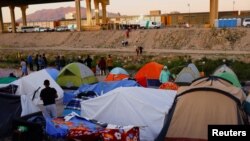 Migrantes venezolanos acampan mientras los de otras nacionalidades intentan cruzar el río Bravo para entregarse a los agentes de la Patrulla Fronteriza de EEUU y solicitar asilo en El Paso, Texas, visto desde Ciudad Juárez, México, el 29 de octubre de 2022.