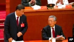 FILE - Chinese President Xi Jinping, left, talks with former President Hu Jintao after giving a speech during the opening ceremony of the 20th National Congress of China's ruling Communist Party at the Great Hall of the People in Beijing, China, Oct. 16, 2022.