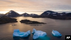 Grandes icebergs flotan mientras sale el sol cerca de Kulusuk, Groenlandia, el 16 de agosto de 2019.