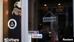 Un comercio en San Salvador muestra a la entrada un cartel que informa de la aceptación del bitcóin en el establecimiento, el 15 de mayo de 2022.