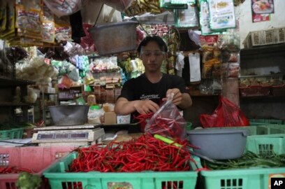 Seorang pedagang cabai mengenakan pelindung wajah untuk mencegah penyebaran wabah virus corona di pasar tradisional Tangerang, Senin, 7 Desember 2020. (Foto: AP)