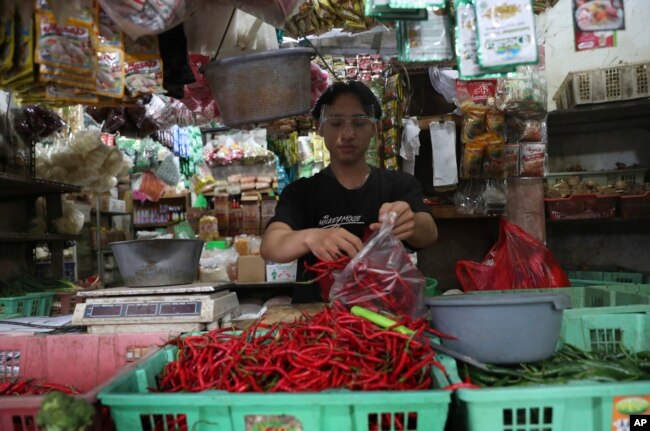 Seorang pedagang cabai mengenakan pelindung wajah untuk mencegah penyebaran wabah virus corona di pasar tradisional Tangerang, Senin, 7 Desember 2020. (Foto: AP)