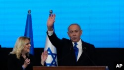 Benjamin Netanyahu, ex primer ministro israelí y líder del partido Likud, acompañado por su esposa Sara, saluda a sus simpatizantes después de conocerse los primeros resultados de los comicios parlamentarios, el 2 de noviembre de 2022, en Jerusalén.