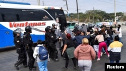 Police block family members of inmates who are allegedly transported in the bus during ongoing prisoner transfers done as part of a government plan to reduce overcrowding in the country's prisons, in Guayaquil, Ecuador Nov. 1, 2022.