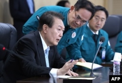 Presiden Korea Selatan Yoon Suk-yeol (kiri) berbicara pada pertemuan Dewan Keamanan Nasional mengenai peluncuran rudal Korea Utara. (Foto: AFP)