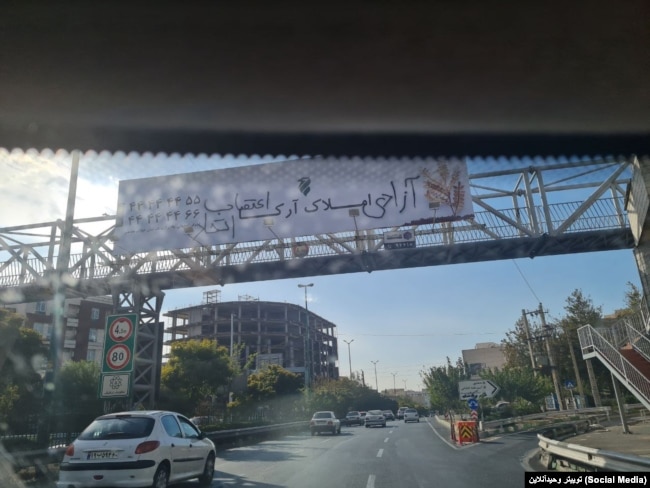 شعار «اتحاد، اعتصاب، انقلاب» بر روی پل عابر پیاده در تهران