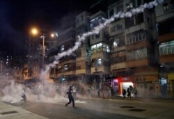 Protesters react to tear gas from Shum Shui Po police station in Hong Kong, Aug. 14, 2019.