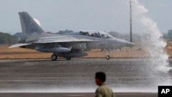 One of two newly acquired FA-50PH fighter jets is given a water cannon salute while taxiing on the runway at Clark Air Base, Philippines, Nov. 28, 2015. 