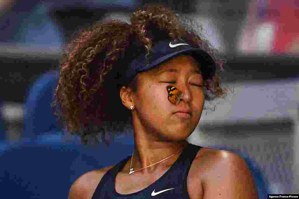 A butterfly lands on Japan&#39;s Naomi Osaka as she plays against Tunisia&#39;s Ons Jabeur during their women&#39;s singles match on day five of the Australian Open tennis tournament in Melbourne, Feb. 12, 2021.