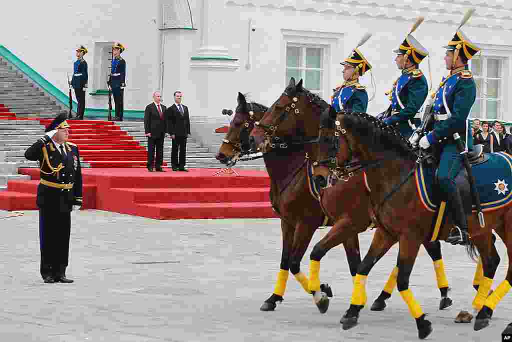 Russian President Vladimir Putin, left back, and former President Dmitry Medvedev watch a parade of the Kremlin's honor guards in Cathedral Square after the inauguration ceremony. (AP)
