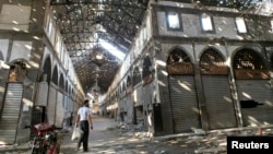 A man walks inside the damaged historical old souk of Homs, August 19, 2013.