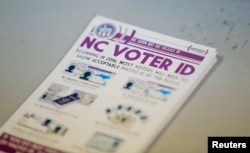 A pile of government pamphlets explaining North Carolina's controversial "Voter ID" law sits on table at a polling station as the law goes into effect for the state's presidential primary in Charlotte, North Carolina, March 15, 2016.