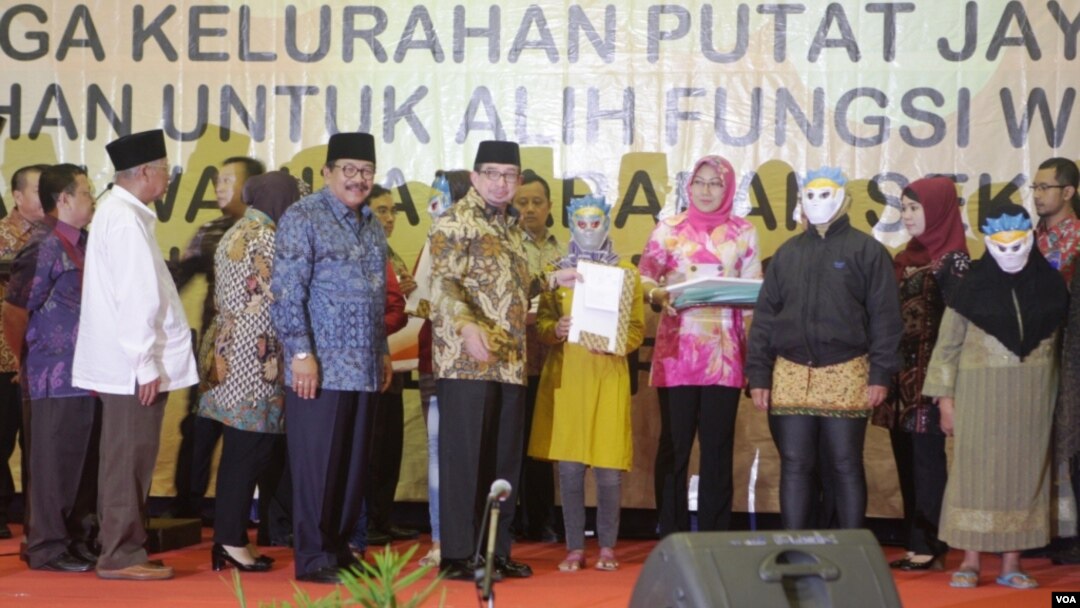 Gubernur Jawa Timur Soekarwo dan Walikota Surabaya Tri Rismaharini, mendampingi Menteri Sosial Salim Segaf Al Jufri, memberikan bantuan Buku Tabungan Secara Simbolis kepada PSK dan Mucikari Dolly dan Jarak di Surabaya, 19 Juni 2014 (Foto:VOA/Petrus)