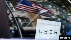 FILE - An Uber sign is seen in a car in New York.