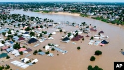 FILE - Houses and other buildings are partially submerged following a dam collapse in Maiduguri, Borno state, Nigeria, on Sept 10, 2024. Health officials say flooding has created ideal conditions for the spread of cholera.