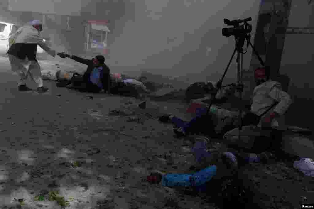 Afghan journalists are seen after a second blast in Kabul.