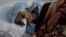An Afghan patient infected with COVID-19 lies on a bed in the intensive care unit of the Afghan Japan Communicable Disease Hospital, in Kabul, Afghanistan, Monday, Feb. 7, 2022. 
